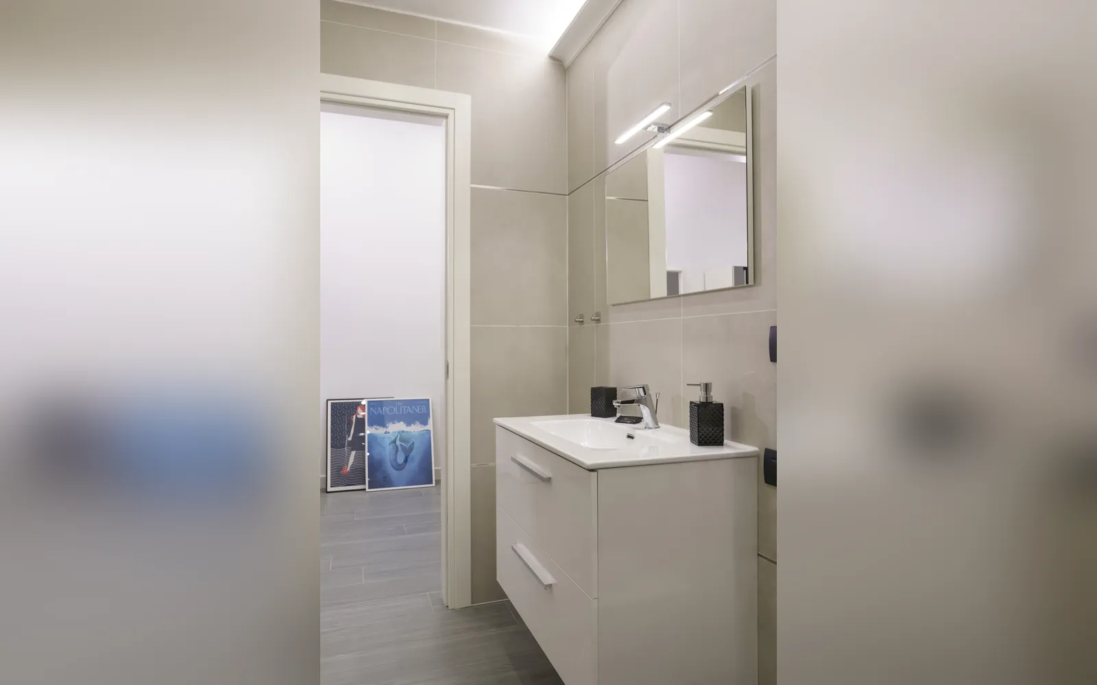 Il bagno con il lavabo sospeso e lo specchio
