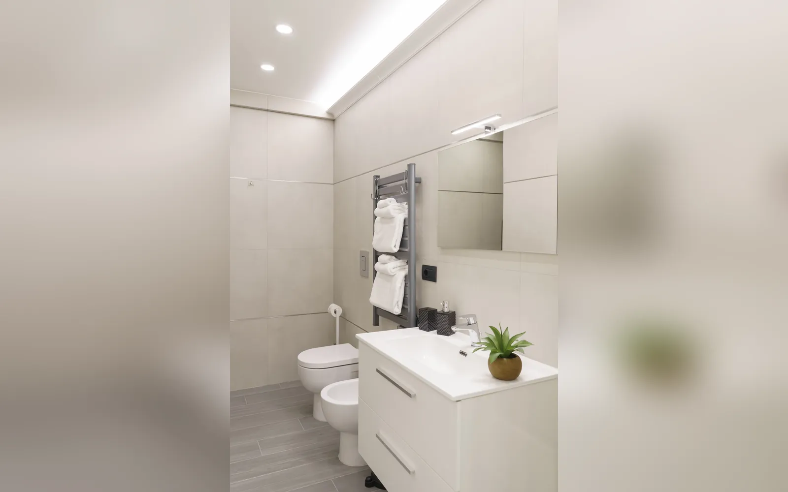 Il bagno con il lavabo sospeso, il bidet e il termoarredo