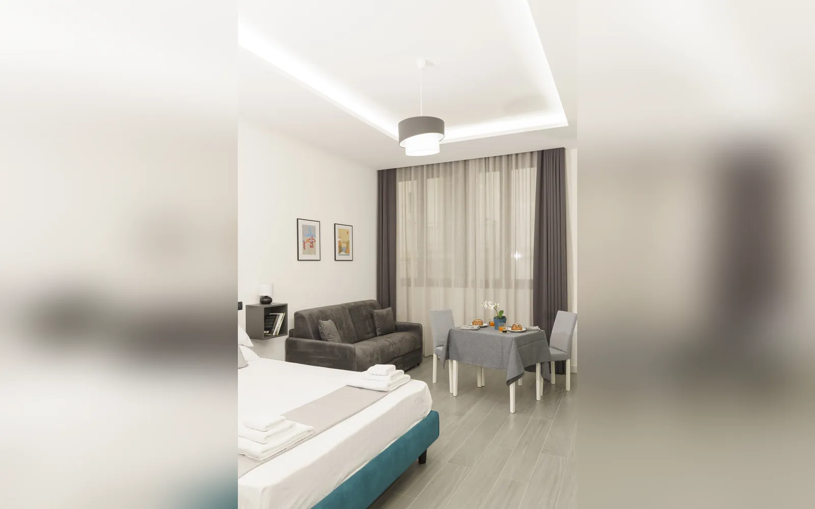 Il monolocale dall’ingresso: letto, divano e tavolo davanti alla finestra