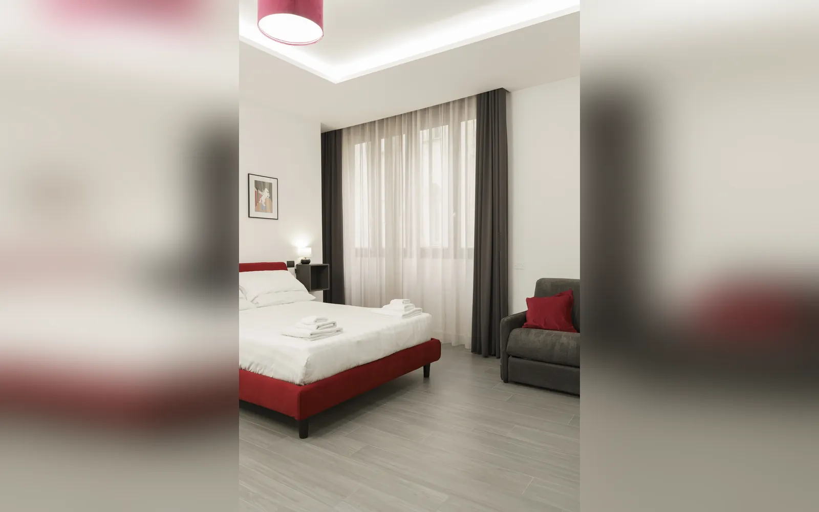 Il letto rosso e il divano nella luce della finestra
