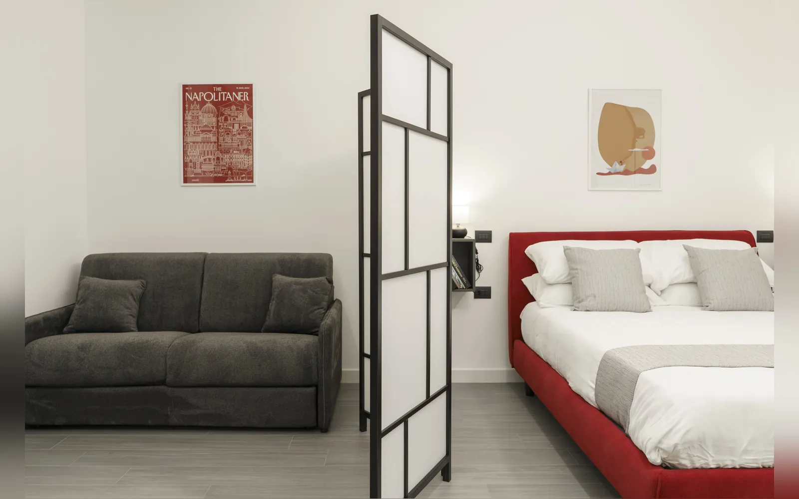 Il divano grigio, il paravento e il letto rosso