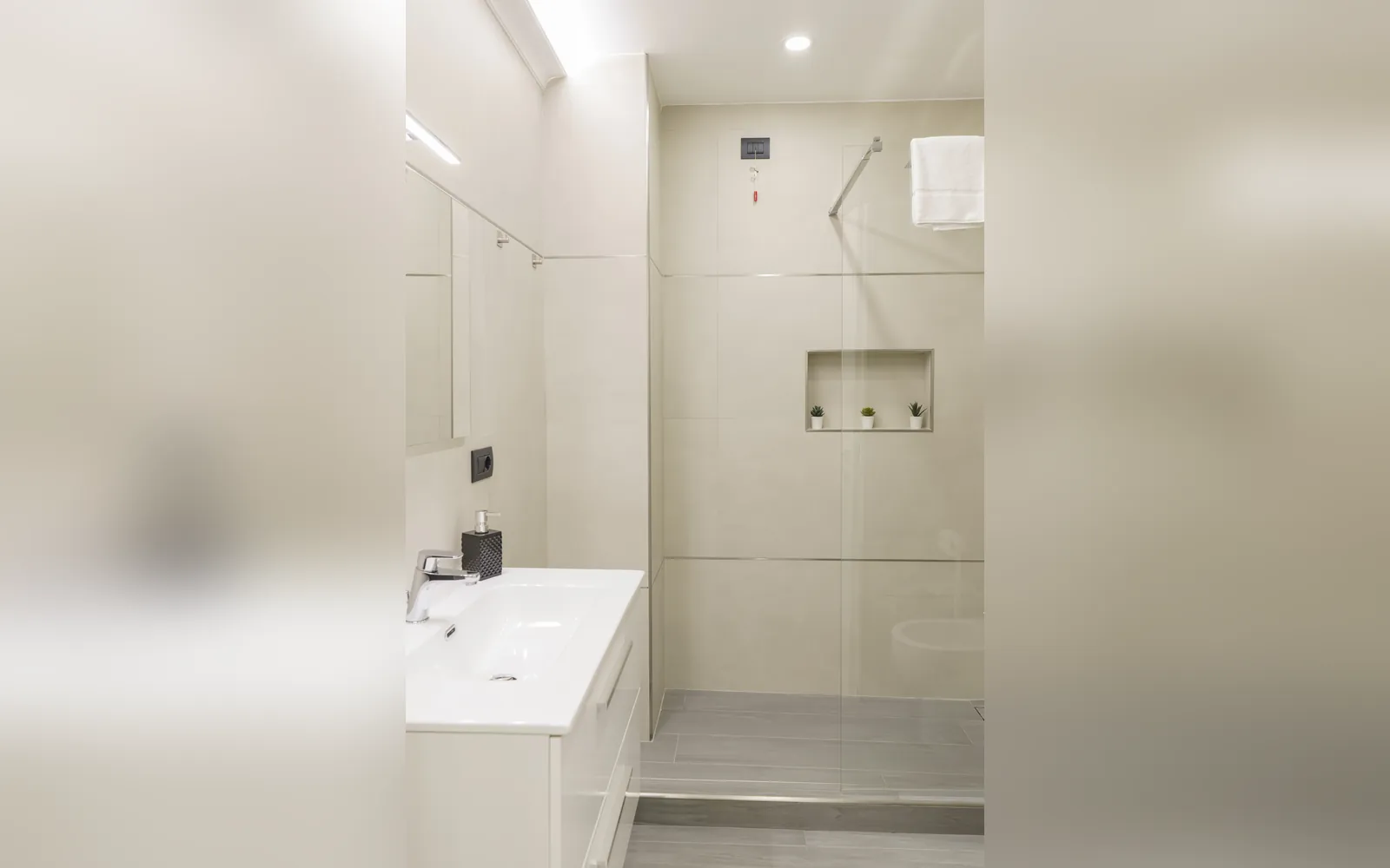 Il bagno con la doccia a filo e il lavabo sospeso